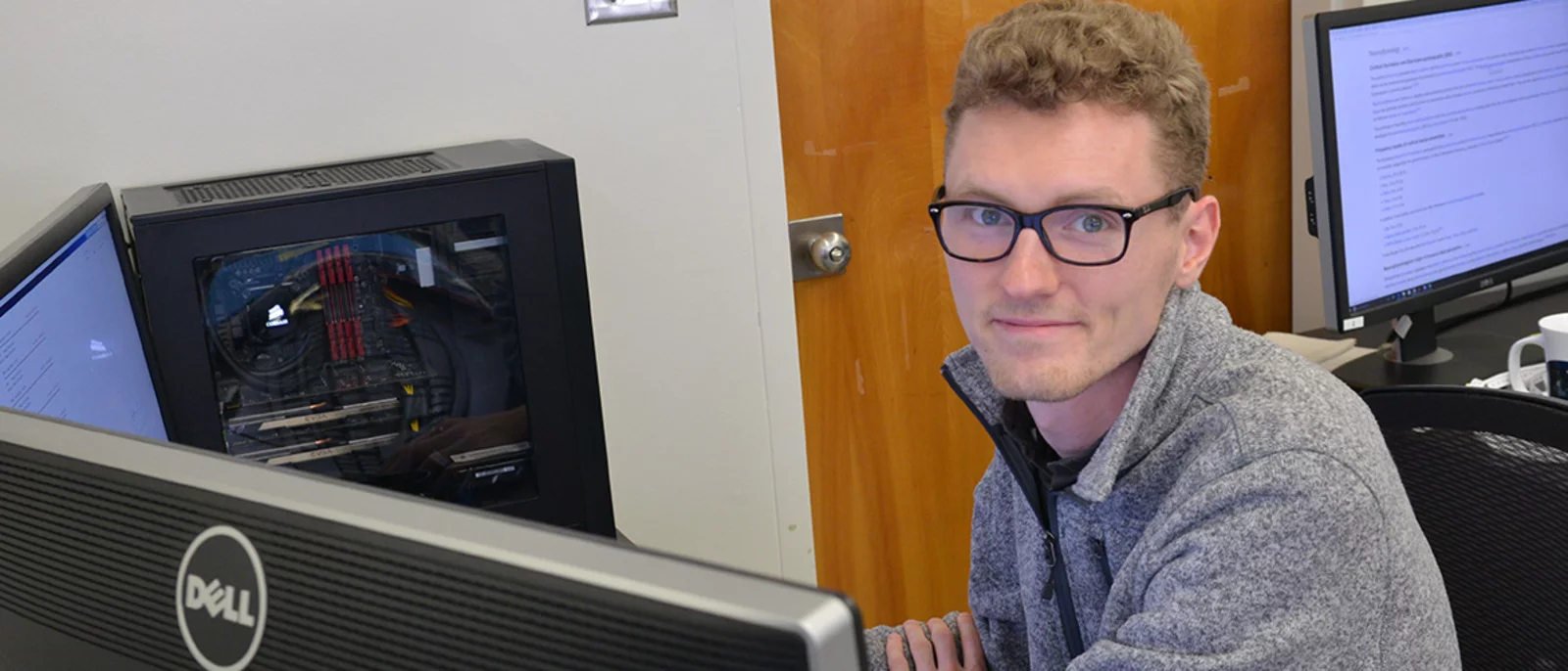 Kumar Lab member is sitting in front of two computer screens. He is analyzing MRI data.